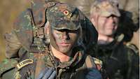 A fully equipped soldier with camouflage face paint