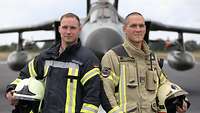 Zwei Soldaten stehen in einer feuerfesten Uniform vor einem Tornado-Kampfjet.