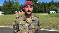 Ein Soldat mit rotem Barett blickt in die Kamera.