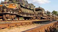 Viele Panzer stehen auf einem Wagon.