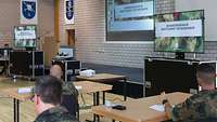 Soldaten sitzen in einem Saal an Tischen