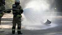 Ein österreichischer Brandschützer löscht einen kleinen Brand.
