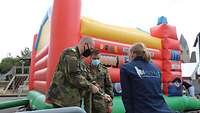 Zwei Soldaten beim Aufbau einer Hüpfburg