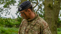 Ein deutscher Soldat in englischer Uniform liest in einem Buch.