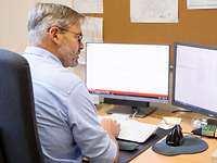 Friedrich sitzt in seinem Büro und arbeitet am Computer