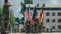 Soldaten mit unterschiedlichen Länderflaggen marschieren auf einen Paradeplatz