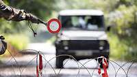 Ein Fahrzeug fährt am Checkpoint auf ein Haltesignal zu.