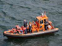 Ein orange farbenes Boot der Bundespolizei mit Zivilisten in Schwimmwesten an Bord.