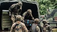 Soldaten laden Material aus einem LKW