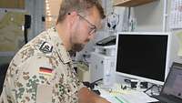 Ein Soldat sitzt im Bürocontainer an seinem Arbeitsplatz
