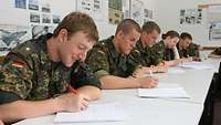 Several soldiers are taking notes.