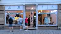 Junge Menschen stehen vor einem Schaufenster mit der Aufschrift Pop Up Karrierelounge der Bundeswehr