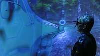 Ein Soldat steht mit einer VR-Brille vor einem großen Bildschirm