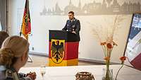 Soldat steht hinter einer Redepult.