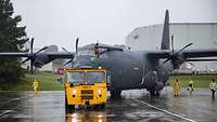 Ein graues Flugzeug ist bei Regen auf dem Rollfeld.