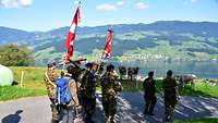 Soldaten mit Fahnen auf dem Pilgerweg, mit Blick auf einen See