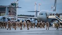 Viele Soldaten verlassen ein Transportflugzeug und laufen auf dem Flugfeld am Fliegerhorst in Wunstorf