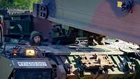 Eine Soldatin in einem Brückenlegepanzer legt eine Panzerschnellbrücke aus