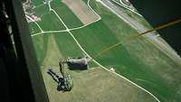 Ein Soldat mit seinem Fallschirm auf dem Rücken, verlässt ein Flugzeug über dem Heeresflugplatz in Altenstadt.