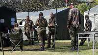 Mehrere Soldaten marschieren in Uniform nebeneinander.