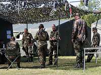 Mehrere Soldaten marschieren in Uniform nebeneinander.