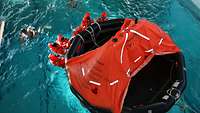 Several people are in a red suit in the water.