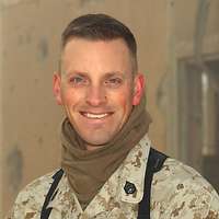 Ein amerikanischer Soldat im Porträt vor einem ausgebombten Gebäude