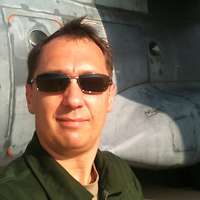 Ein Soldat mit Sonnenbrille im Porträt vor einem Flugzeug