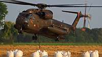Ein Hubschrauber CH-53 transportiert Sandsäcke ins Hochwassergebiet
