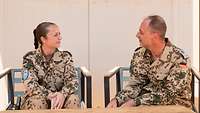 Eine Soldatin und ein Soldat sitzen an einem Tisch nebeneinander 