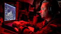 Ein Soldat sitzt unter Rotlicht im Gefechtssimulator
