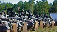 Mehrere Schützenpanzer stehen an einer Schießbahn in einer Reihe aufgefahren