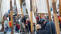 Viele Menschen mit Rettungswesten auf Segelbooten.