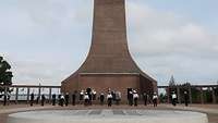 Mehrere Menschen stehen vor dem Marineehrenmal in Laboe.