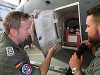 Batterie-Check Zwei Soldaten stehen an der C-130J an einer geöffneten Klappe