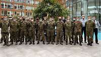 Soldaten in Flecktarnuniform stehen als Gruppe aufgestellt.