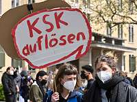Demonstranten mit Schild „KSK auflösen“ in Berlin Eine Demonstrantin hält ein Pappschild mit der Aufschrift „KSK auflösen“
