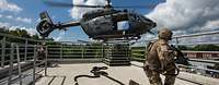 4. Staffel des Hubschraubergeschwaders 64 Zwei bewaffnete Soldaten knien auf dem Dach eines Gebäudes, neben dem ein Hubschrauber schwebt