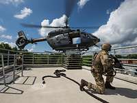 4. Staffel des Hubschraubergeschwaders 64 Zwei bewaffnete Soldaten knien auf dem Dach eines Gebäudes, neben dem ein Hubschrauber schwebt