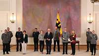 Der Bundespräsident steht in der Mitte, neben ihm zahlreiche Personen sowie die Verteidigungsministerin