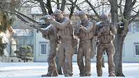 Denkmal Kaserneneingang Calw Ein Statue von vier Soldaten mit Waffen im Anschlag
