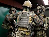KSK-Soldaten Calw Drei Soldaten stehen zusammen und besprechen sich