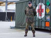 Flottenapotheker Martin Pape Ein Soldat steht vor einem Container mit einem roten Kreuz darauf