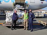 Impfstofflieferung nach Namibia Drei Männer, davon zwei in Uniform, stehen vor einem Flugzeug.