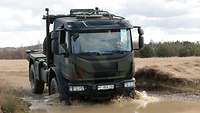 Ein Bundeswehr-LKW des Landesregiments fährt in schwerem Gelände.