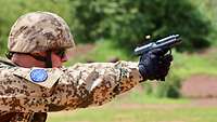 Ein Soldat beim Schießtraining, er hält eine Pistole in der Hand.