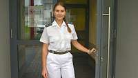 Eine Soldatin in weißer Arztkleidung steht in der Eingangstür des Sanitätsversorgungszentrums Cochem.