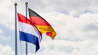 Die niederländische und die deutsche Flagge wehen im Wind