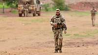 Ein Soldat läuft auf einer Sandpiste