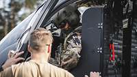 Pilot und Mechaniker Ein Soldat steht an der Tür eines Mehrzweckhubschraubers H145M LUH SOF und spricht mit dem Piloten